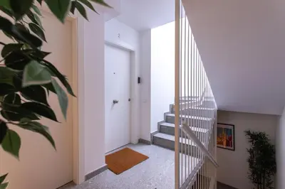 a hallway with stairs and a white door at StayCampNou 1BR with Balcony in Hospitalet de Llobregat
