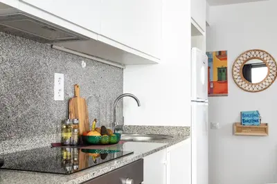a kitchen counter with a sink and a bowl of fruit at StayCampNou 1BR with Balcony in Hospitalet de Llobregat