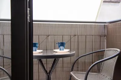 a small table with two blue vases on it at StayCampNou 1BR with Balcony in Hospitalet de Llobregat