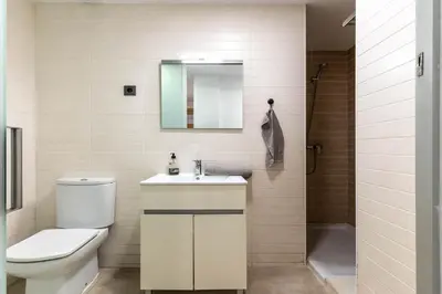 a bathroom with a toilet and a sink and a mirror at Acogedor apartamento Diagonal Mar in Barcelona