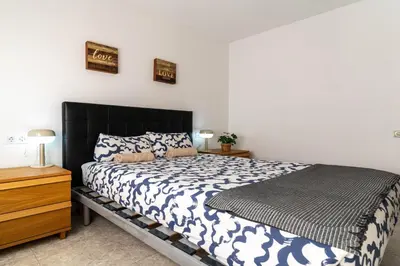 a bedroom with a bed with a black headboard at Bonito apartamento Camp Nou in Barcelona