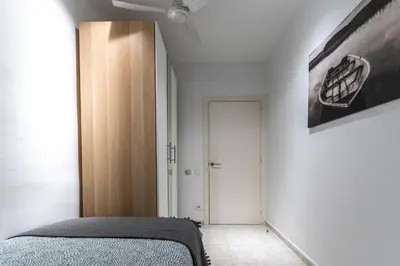 a bedroom with a bed and a painting on the wall at Bonito apartamento Camp Nou in Barcelona