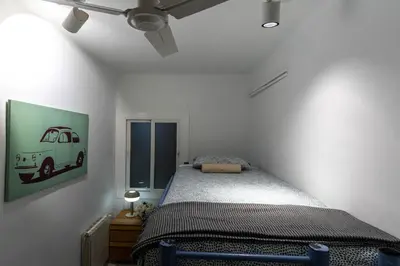 a bedroom with a bed and a picture of a van on the wall at Bonito apartamento Camp Nou in Barcelona