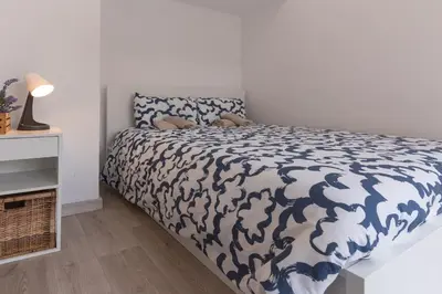 a bedroom with a bed with a blue and white comforter at Hermoso apartamento en el centro in Barcelona