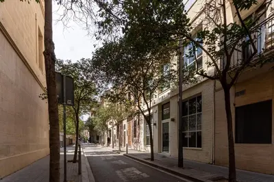 an empty city street with trees and buildings at Magnífico apartamento en el centro in Barcelona