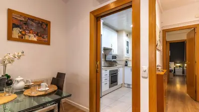 a kitchen with white cabinets and a table with a table sidx sidx sidx at Nuevo apartamento zona Paseo de Gracia in Barcelona