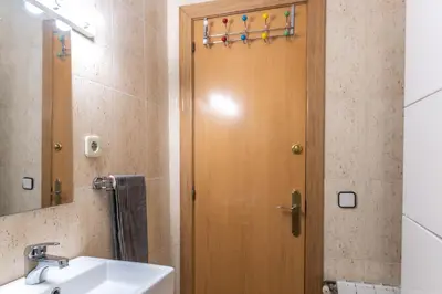 a bathroom with a wooden door next to a sink at Nuevo apartamento zona Paseo de Gracia in Barcelona