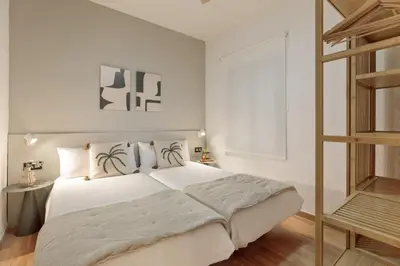 a bedroom with a large white bed and a ladder at Precioso apartamento en el Centro in Barcelona