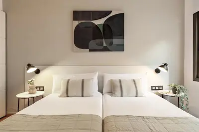 a bedroom with a large white bed with two tables at Precioso apartamento en el Centro in Barcelona