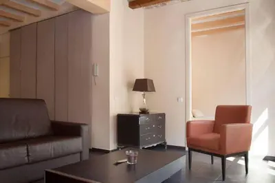 a living room with a couch and a chair at EL born - spacious 2 bedrooms in Barcelona