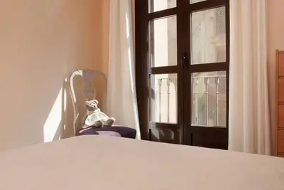 a stuffed teddy bear sitting in a chair next to a window at EL born - spacious 2 bedrooms in Barcelona