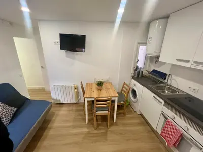 a small apartment with a table and a kitchen at Charming and quiet apartments near Barcelona in Hospitalet de Llobregat