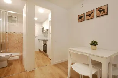 a white dining room with a table and a toilet at Charming and quiet apartments near Barcelona in Hospitalet de Llobregat
