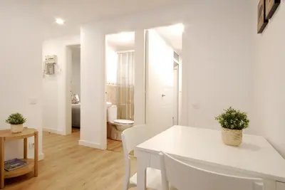 a white dining room with a white table and chairs at Charming and quiet apartments near Barcelona in Hospitalet de Llobregat