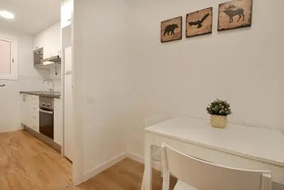 a white kitchen with a white table and a counter at Charming and quiet apartments near Barcelona in Hospitalet de Llobregat