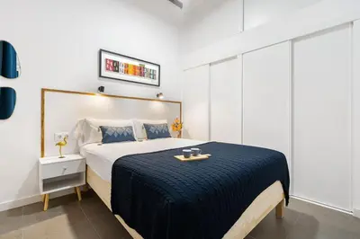 a bedroom with a large bed with a tray on it at Lodging Apartments Almirall Beach B2 in Barcelona