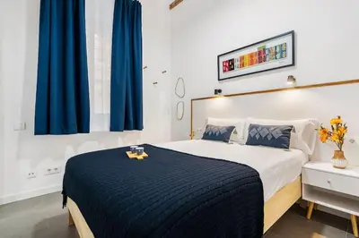 a bedroom with a large bed with a blue blanket at Lodging Apartments Almirall Beach B2 in Barcelona