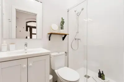 a white bathroom with a toilet and a shower at Lodging Apartments Almirall Beach B2 in Barcelona