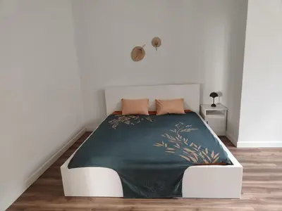 a bedroom with a bed with a green blanket on it at Apartment in Premia de Dalt