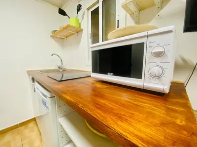 a microwave sitting on top of a wooden counter in a kitchen at 45 Center Basic 1 2 in Barcelona