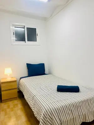 a bedroom with a bed with a blue pillow on it at 45 Center Basic 1 2 in Barcelona