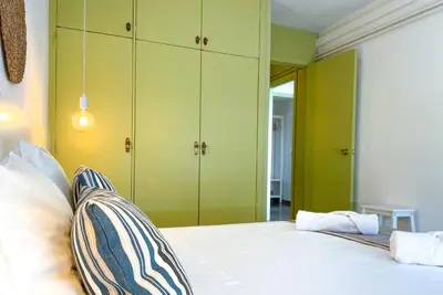 a bedroom with a large bed with green cabinets at Apartment Vicente in Vilanova i la Geltrú