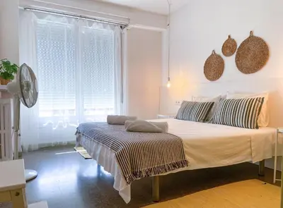 a bedroom with a bed and a large window at Apartment Vicente in Vilanova i la Geltrú