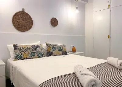 a white bedroom with a bed with two pillows at Apartment Vicente in Vilanova i la Geltrú