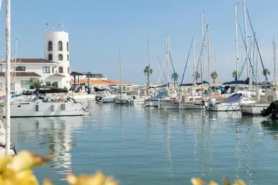 a group of boats docked in a marina with a lighthouse at Esencia Mediterránea Precioso en primera linea in Sitges