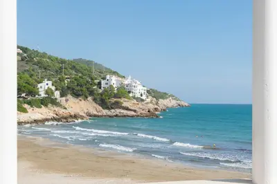 a beach with white houses on a hill next to the ocean at Esencia Mediterránea Precioso en primera linea in Sitges