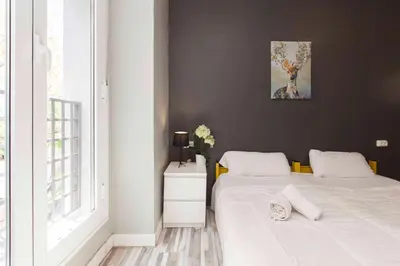 a bedroom with two beds and a painting on the wall at HeyLola! Hostel in Barcelona