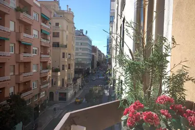 a view of a city street from a balcony with flowers at Lets Holidays Centric Apartment in Barcelona in Barcelona