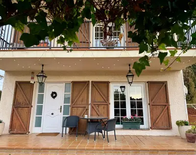 a patio with a table and chairs in front of a house at Casa Annie in Collbató