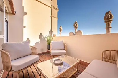 a patio with two chairs and a table and avisor at The Diagonal Suites Atic by Sweett in Barcelona