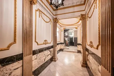 an ornate hallway with columns and paintings on the walls at The Diagonal Suites Atic by Sweett in Barcelona