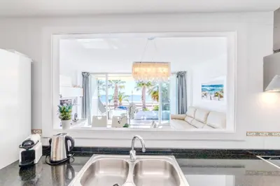 a kitchen with a sink and a large window at Frente a mar salida directa playa solo 30M agua in Cubelles