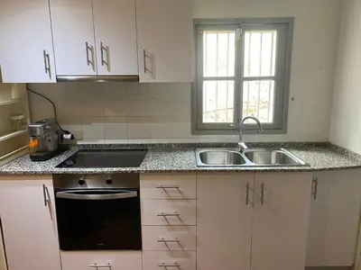 a kitchen with white cabinets and a sink and a window at Piso Rustico Calle de la Font Vilafranca del penedes in Vilafranca del Penedès
