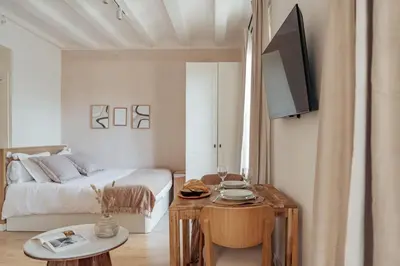 a bedroom with a bed and a table with a tv at Casa Atrio - Wonderful studio near Barcelona cathedral in Barcelona