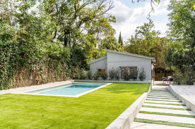 a backyard with a swimming pool and green grass at Villa Atardecer in Barcelona