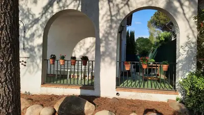 an arched doorway with potted plants on a fence at La Garsa in Aiguafreda