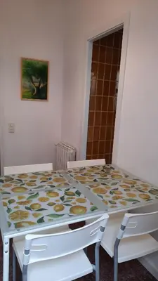 a dining room table with two white chairs at La Garsa in Aiguafreda