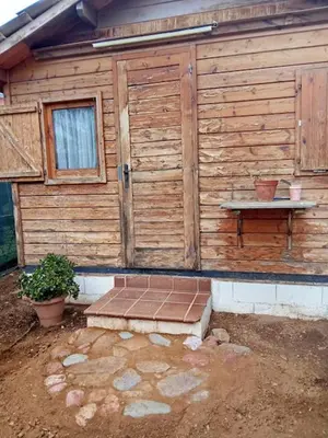 a wooden cabin with a bench in front of it at Cool Bungalow in Matadepera