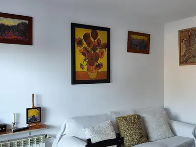 a living room with a couch and paintings on the wall at Ca La Dulcet in Gélida