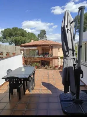 a patio with a table and an umbrella at Ca La Dulcet in Gélida