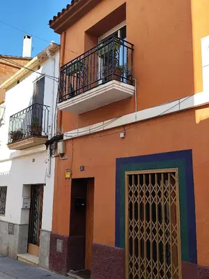 an orange building with two balconies and a door at Ca La Dulcet in Gélida
