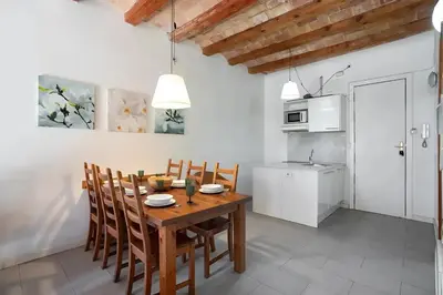 a kitchen and dining room with a wooden table and chairs at Mooeve Sant Antoni in Barcelona