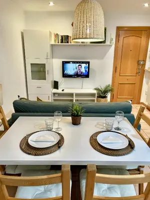 a dining room table with two chairs and a tv at Apartamento Sant Josep in Canet de Mar