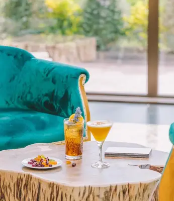 a table with a drink and a plate of food on it at Mas Salagros EcoResort & SPA in Vallromanas