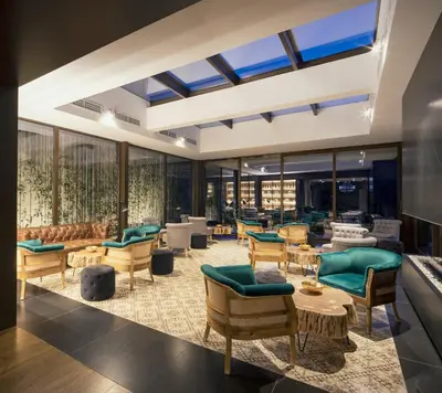 a lobby with chairs and tables and windows at Mas Salagros EcoResort & SPA in Vallromanas