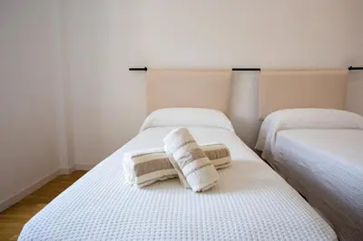 two beds in a room with towels on them at Suitur apartamento exclusivo céntrico Barcelona in Barcelona